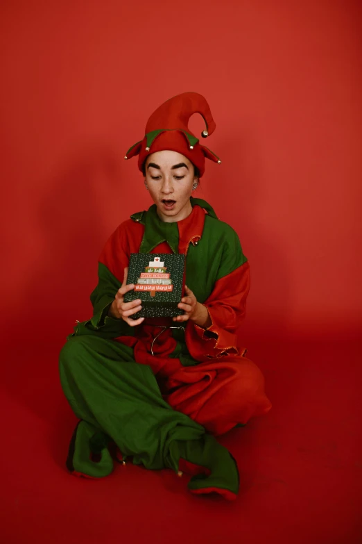 a woman dressed in green sitting on the floor holding a cake