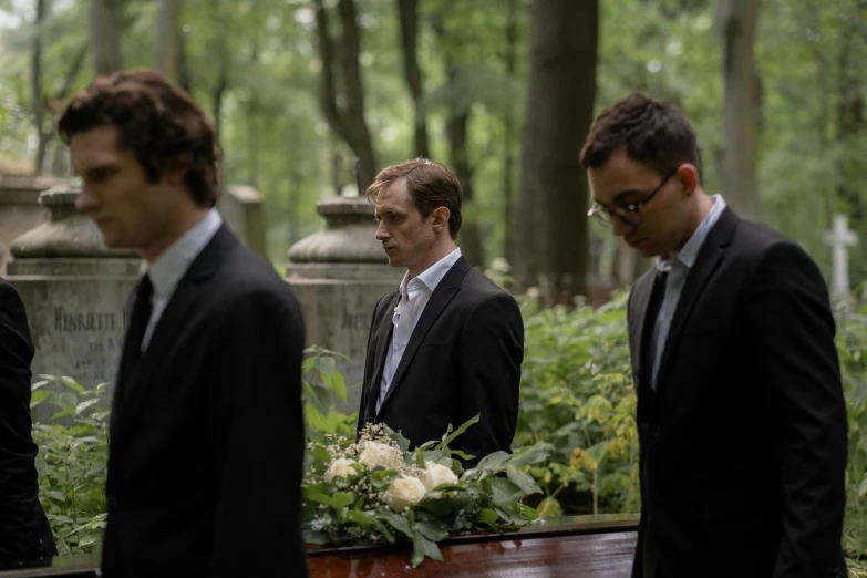 a group of men standing around a casket, an album cover, by Sebastian Vrancx, pexels, looks sad and solemn, **cinematic, cementary, profile image