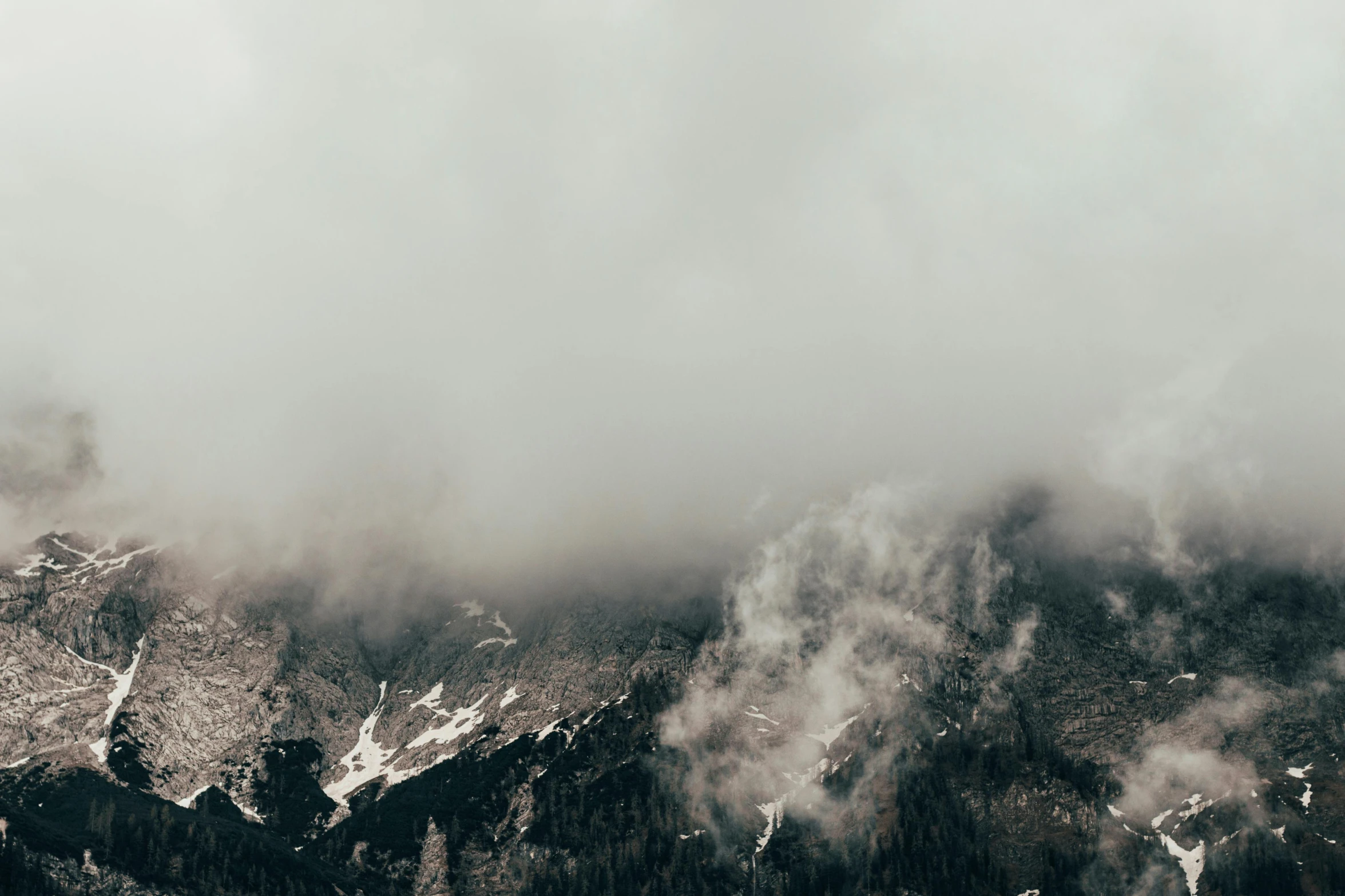 an overhead view of some mountains covered in mist