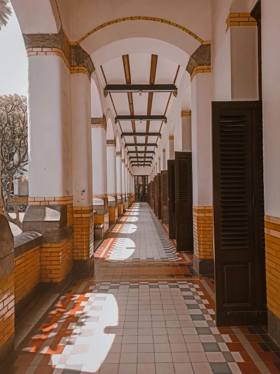 the hallway in the building has tile on the floor and door handles