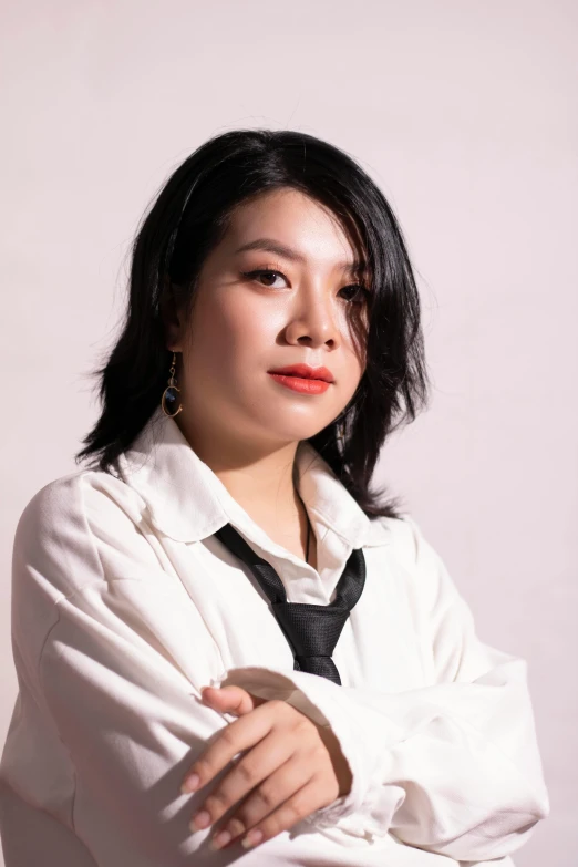 a woman in a white shirt and black tie, an album cover, inspired by Feng Zhu, pexels contest winner, south east asian with round face, casual pose, smol, vp of marketing