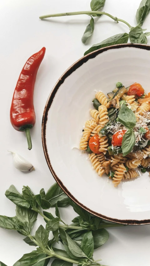 a white bowl filled with pasta and vegetables, by Carey Morris, pexels, renaissance, instagram picture, basil, thumbnail, spicy