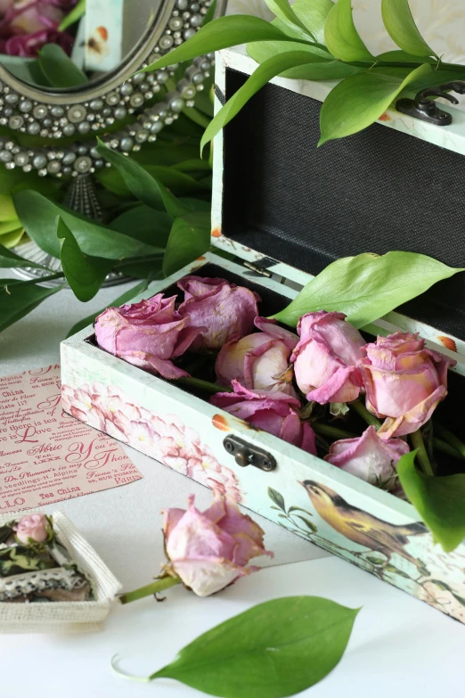 a flower arrangement placed inside an open wooden box