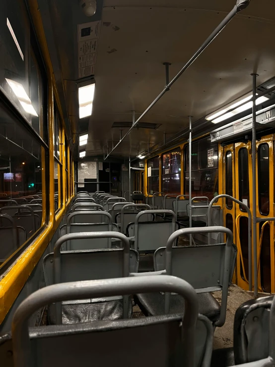 some empty yellow and grey bus seats in a building