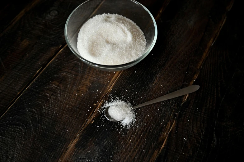 a bowl of sugar and a spoon on a wooden table, a portrait, pexels, process art, background image, square, 🍸🍋, half turned around