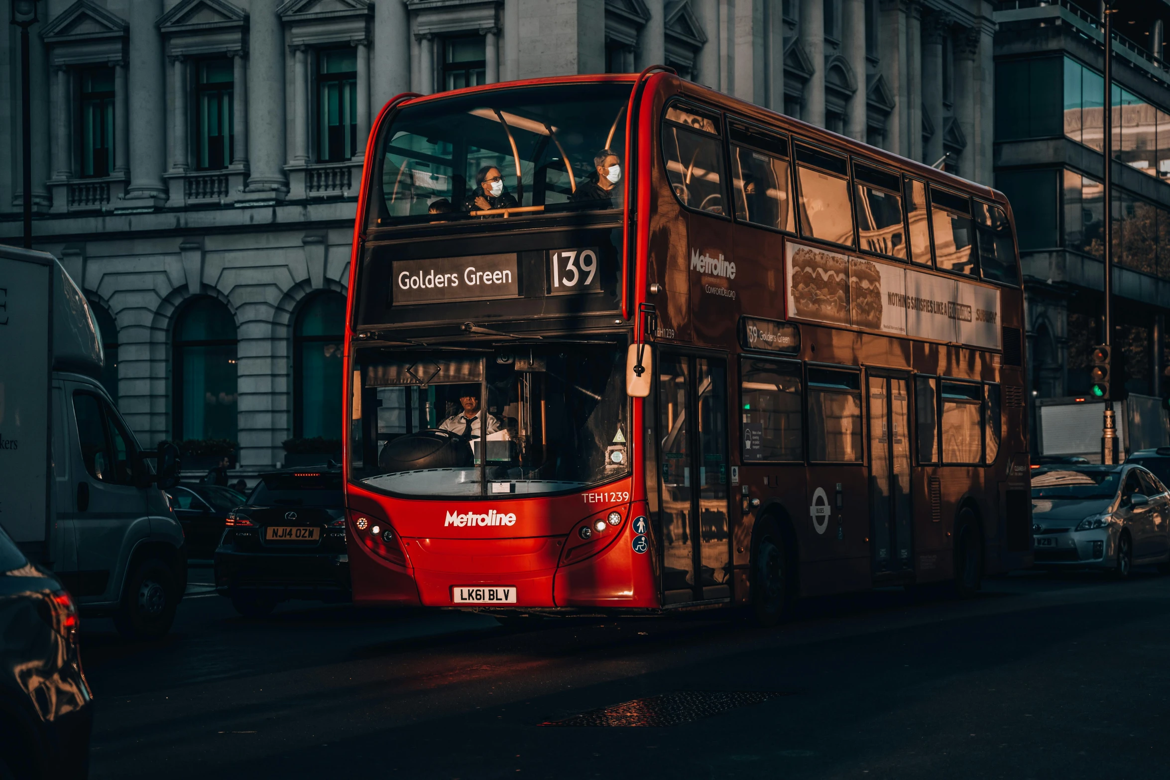 red double decker bus driving down the street