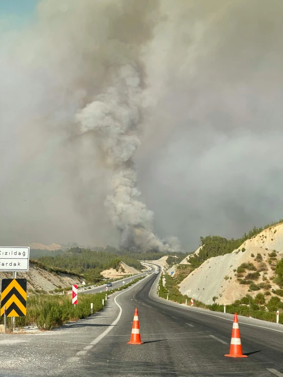 an old smoke column rising over a rural road