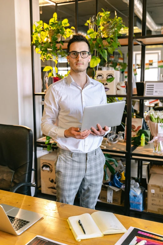 a man standing in front of a laptop computer, jovana rikalo, in an office, next to a plant, profile image