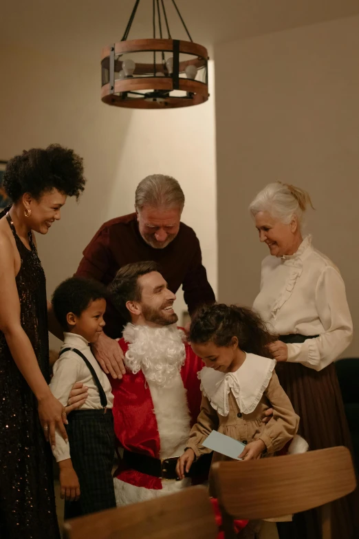 a group of people standing around a table, inspired by The Family Circus, pexels, sitting on santa, embracing, gif, ignant