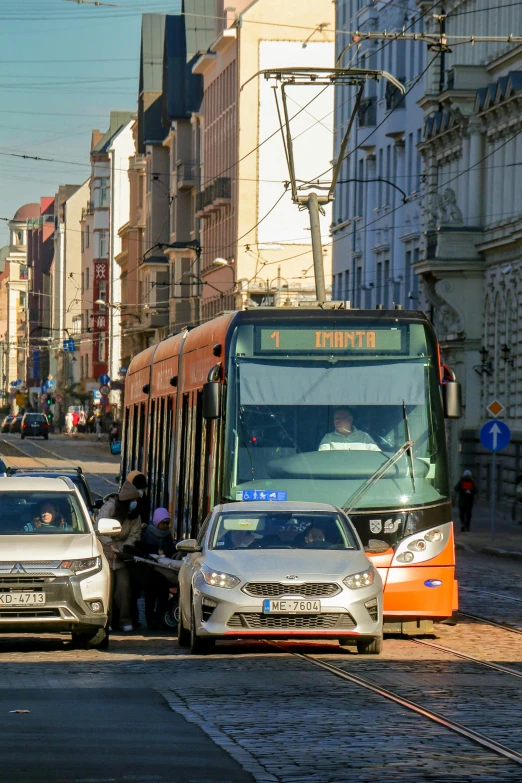 a bus and cars on a street, with the traffic getting ready to get
