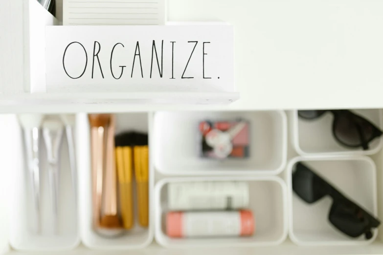 a close up of a drawer with a sign on it, by Nicolette Macnamara, unsplash, makeup, white, organized, dezeen