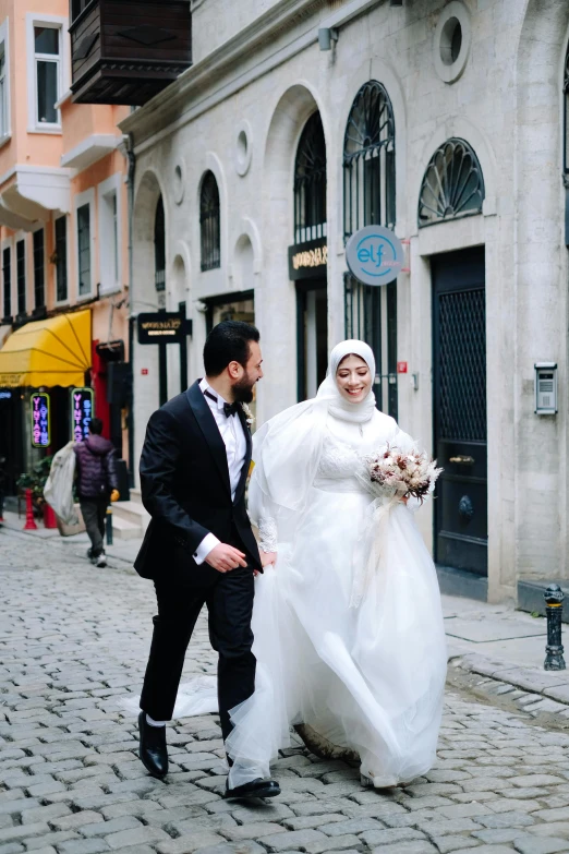 a bride and groom walking down a cobblestone street, an album cover, pexels contest winner, hurufiyya, ottoman sultanate, gif, chiffon, ( ( theatrical ) )