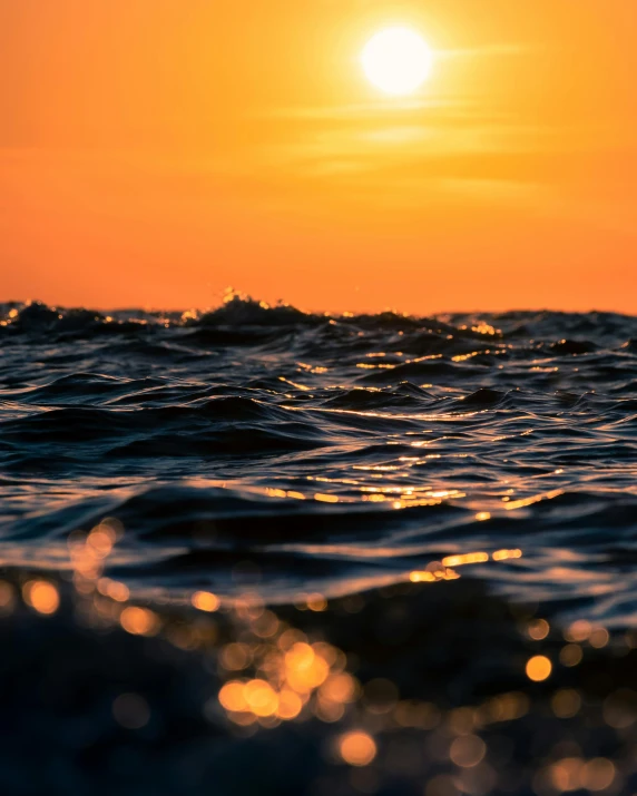 the sun is setting over a body of water, pexels contest winner, wavy water, heat shimmering, looking left, low - angle shot