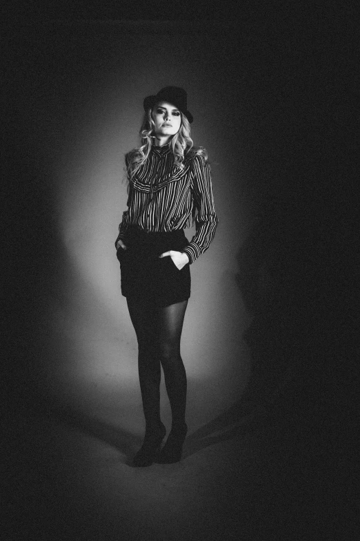 a black and white photo of a woman in tights, inspired by August Sander, annasophia robb, wearing a fedora, black backdrop!, seventies era