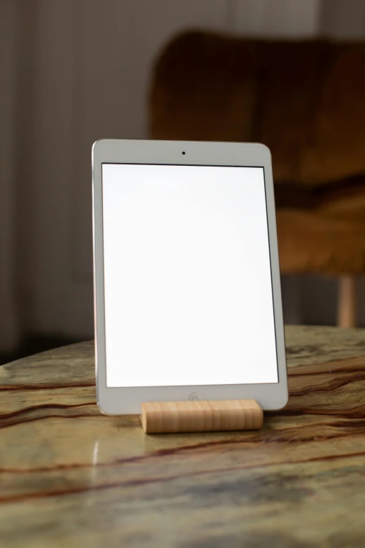 a tablet computer sitting on top of a wooden table, inspired by Isamu Noguchi, vanilla - colored lighting, front shot, light sensor, test