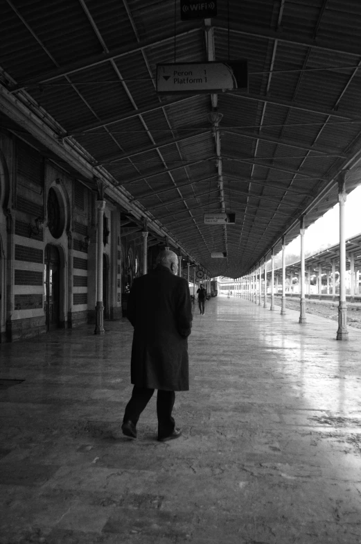 a man walking in an enclosed area at a station