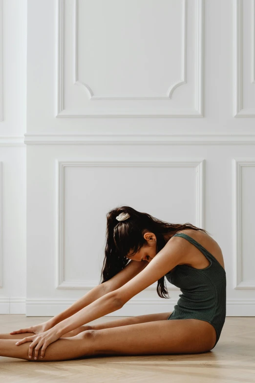 a woman in a green leo leo leo leo leo leo leo leo leo leo leo leo leo, trending on pexels, arabesque, sitting on the floor, waist reaching ponytail, in white room, back arched