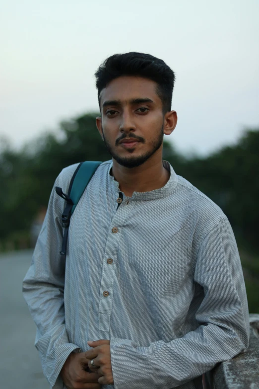 a man with a backpack standing on a bridge, by Ismail Acar, hurufiyya, halfbody headshot, short neck, vinayak, (((low light)))