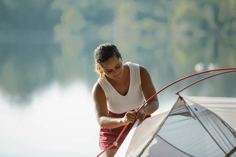 a woman setting up a tent on a dock, pexels contest winner, fan favorite, pulling strings, avatar image, handsome