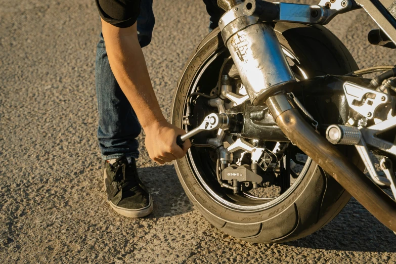 a close up of a person working on a motorcycle, 🚿🗝📝, holding a wrench, avatar image, slick tires