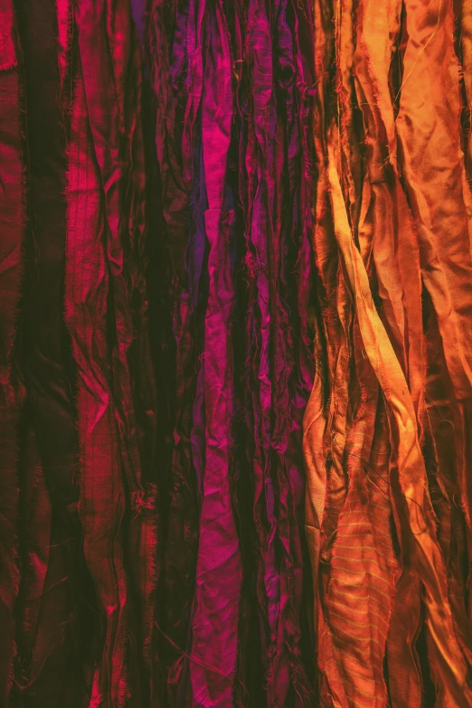 a bunch of different colored fabric hanging on a wall, pexels contest winner, lyrical abstraction, shades of aerochrome gold, high detailed thin stalagtites, brown and magenta color scheme, dark neon colored rainforest