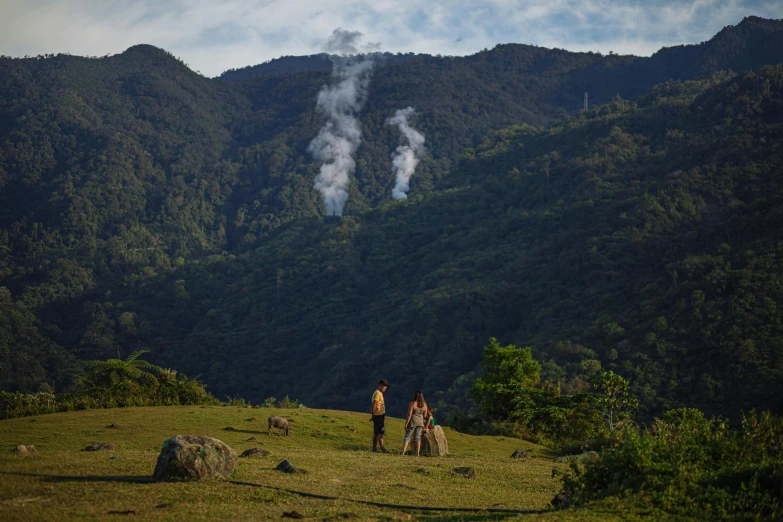 there is a small cloud coming from a small hill