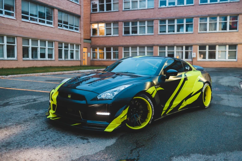 the black and yellow car is parked in front of an apartment building