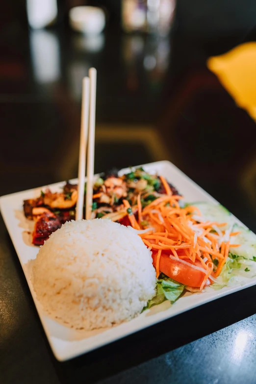 a close up of a plate of food with chopsticks, offering a plate of food, square, nivanh chanthara, medium angle