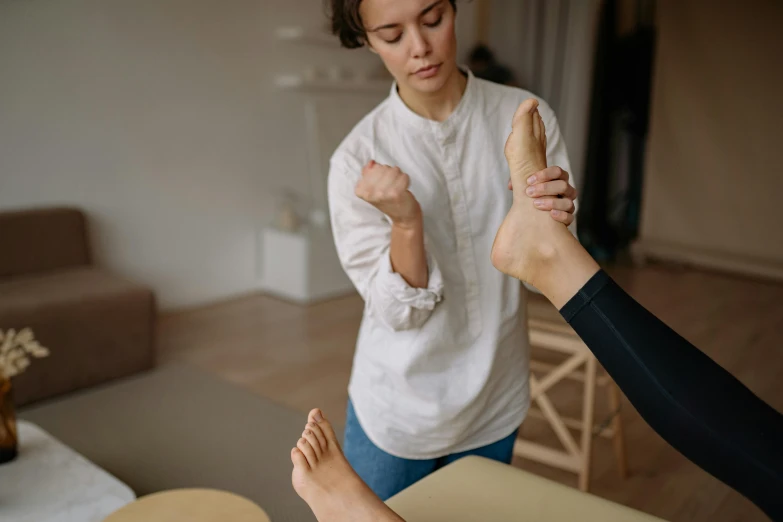 a woman getting a foot massage in a living room, trending on pexels, standing sideways, hyperrealism photo, thumbnail, body format