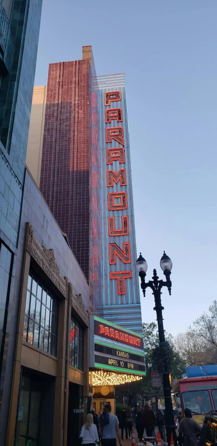 a crowd of people standing outside of a tall building