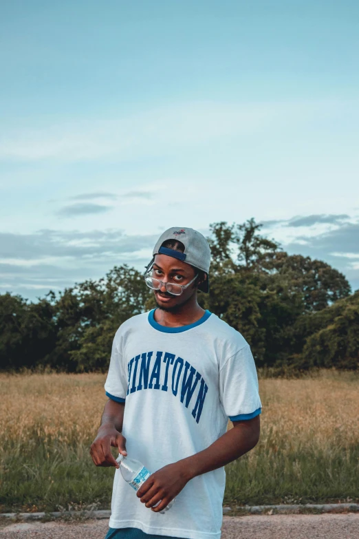 a man standing next to a field with trees