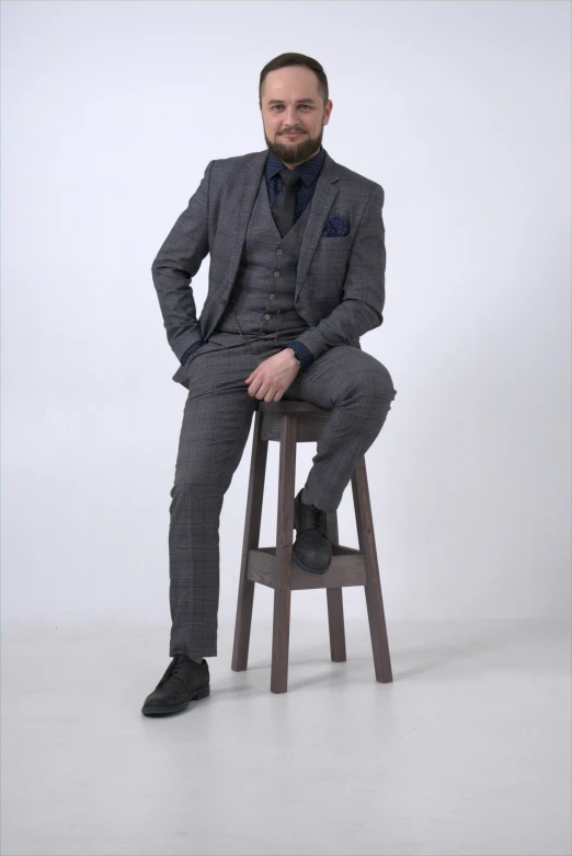 a man in a suit sitting on a stool, three piece suit, caparisons, zoomed out full body, 165 cm tall
