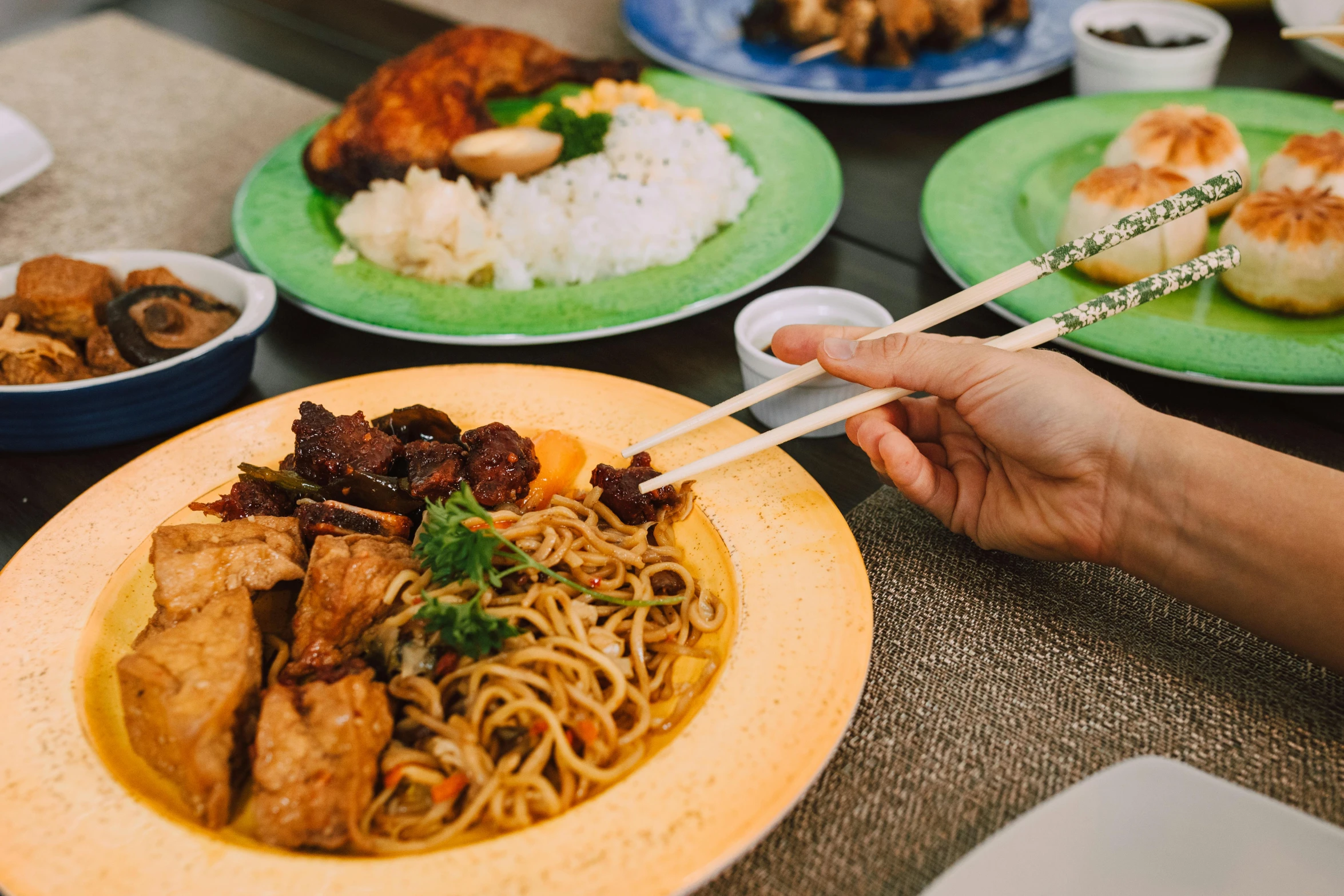 a person holding chopsticks over a plate of food, square, malaysian, background image, alana fletcher