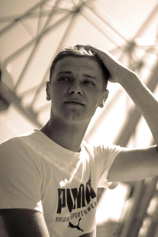 a young man adjusts his hair in a black and white po