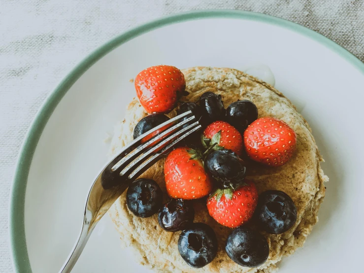 a white plate topped with pancakes and berries