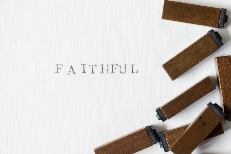 a group of clothes pegs sitting on top of a piece of paper, inspired by Andrew Boog Faithfull, unsplash, faithful, calligraphy, carved in wood, ffffound