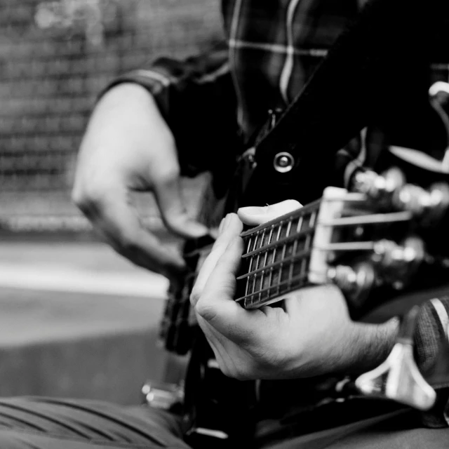 a close up of a person playing a guitar, a picture, by Kristian Zahrtmann, uploaded, street photo, realistic »