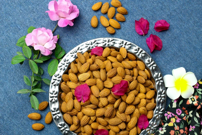 a plate of almonds and flowers on a table, trending on pixabay, renaissance, on a velvet table cloth, listing image, nepal, 🐿🍸🍋