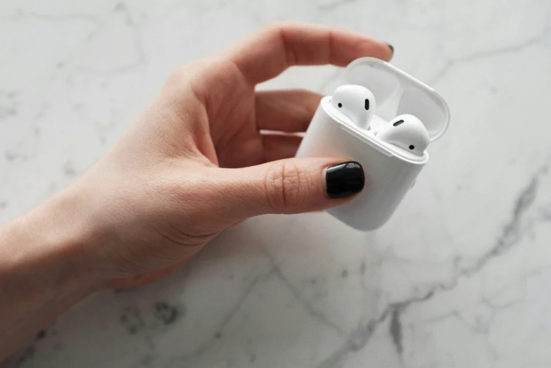 a person holding an airpods in their hand, by Christen Købke, trending on pexels, square, white marble, apples, glossy white metal