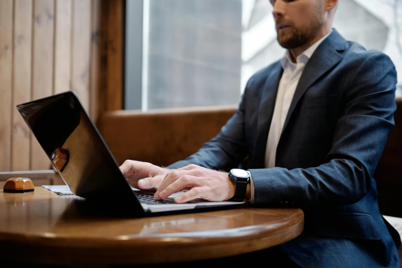 a man sitting at a table using a laptop computer, by Carey Morris, pexels contest winner, wearing business casual dress, lachlan bailey, wearing a business suit, thumbnail