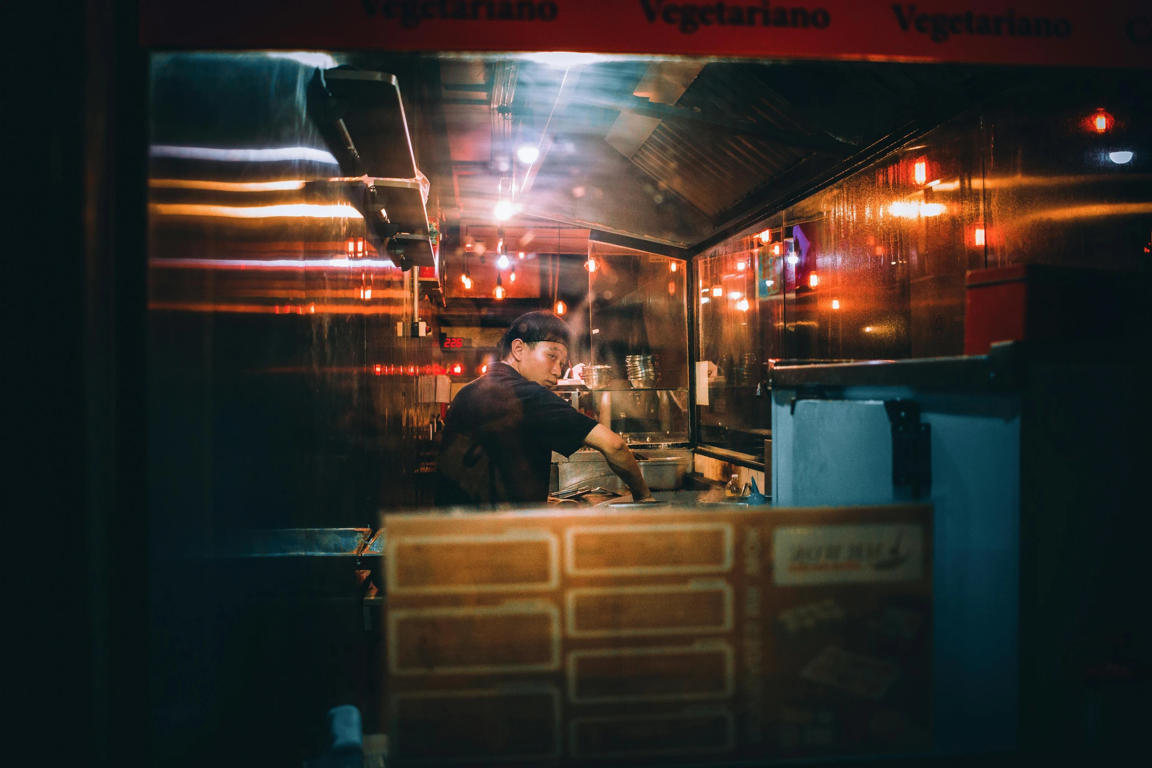 two people in an industrial kitchen at night