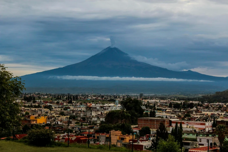 a city below a mountain in the middle of the day