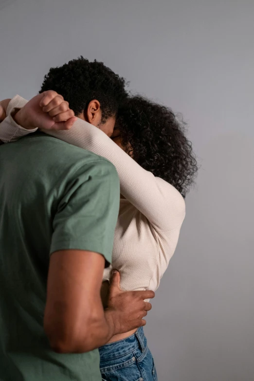 a man and a woman hugging each other, timid and vulnerable expression, back view. nuri iyem, african american, square