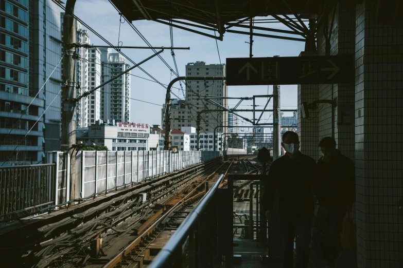 a couple of people standing on a train platform, a picture, unsplash contest winner, kowloon walled city, rail tracks lead from the mine, monorail, no people