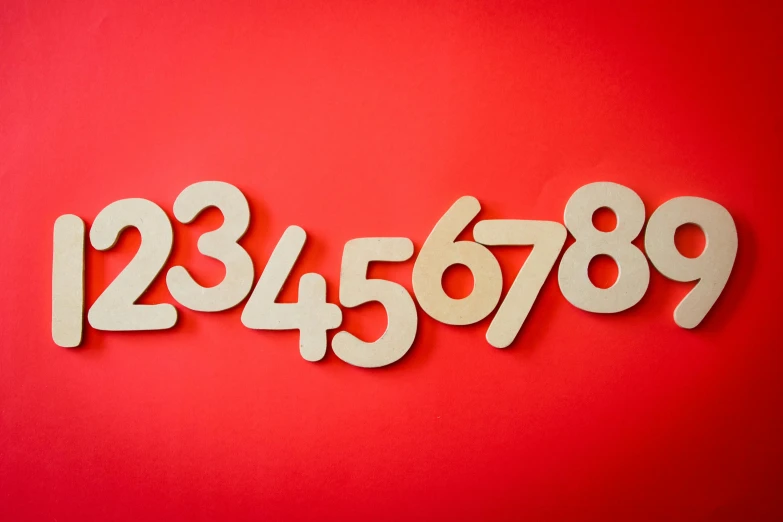 a number of wooden numbers on a red background, by Matthias Stom, trending on unsplash, wall art, wooden art toys, very large, matt finish