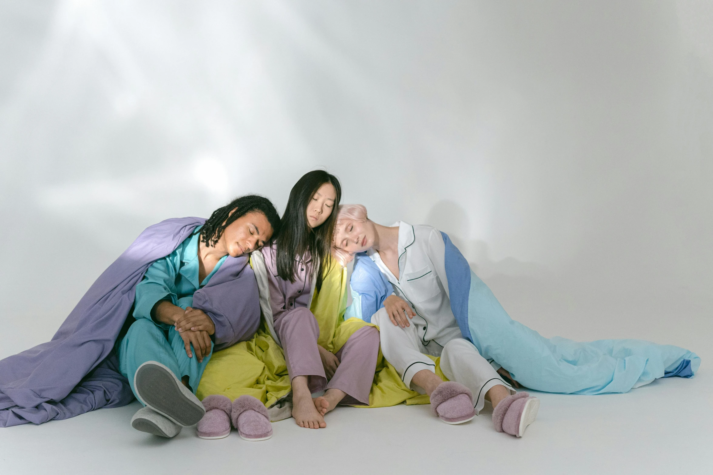 a group of three women sitting next to each other, inspired by Russell Dongjun Lu, synchromism, wearing pajamas, 3 colours, laying on their back, joy ang