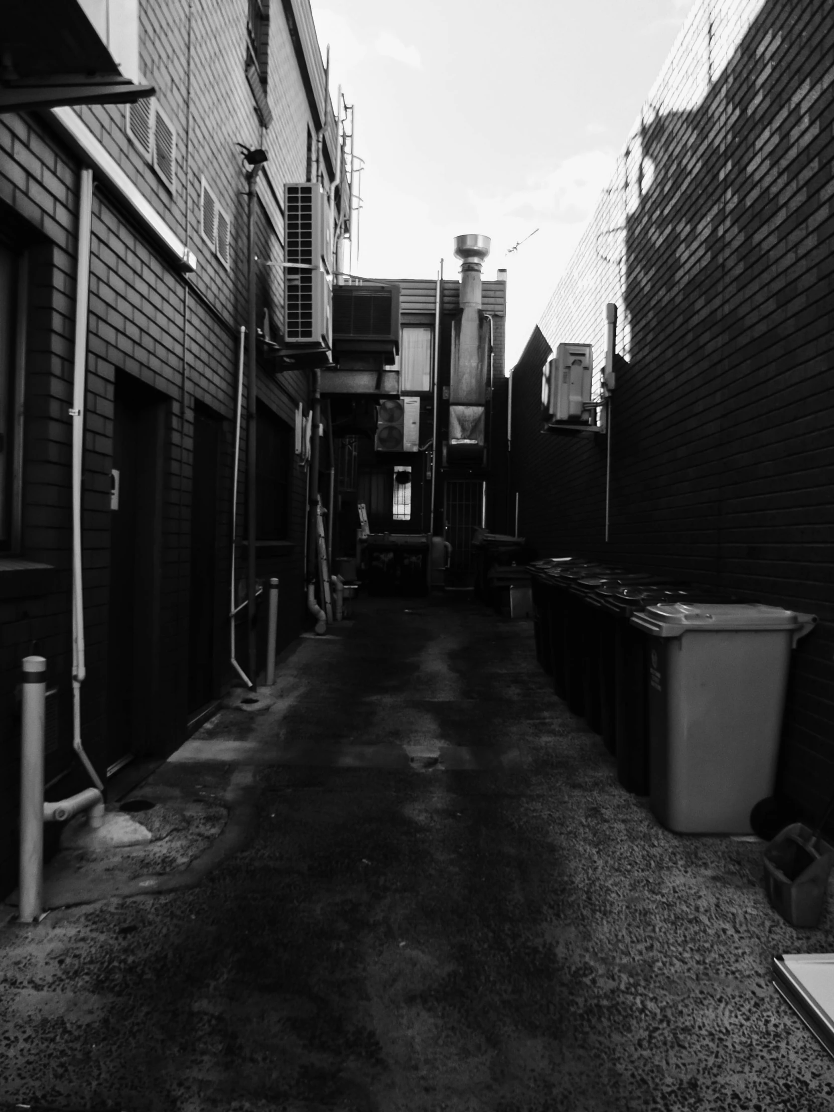 a black and white photo of a narrow alley, a black and white photo, by Ben Thompson, north melbourne street, cinematic. by leng jun, andrew dickson, phone photo