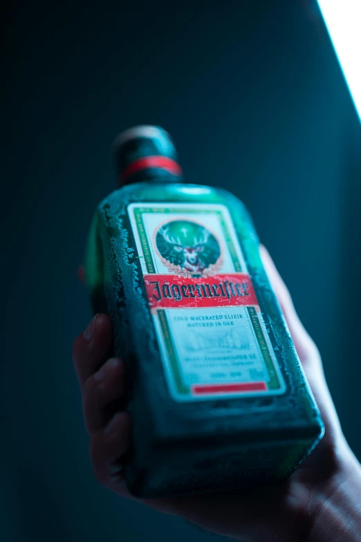 a person holding a bottle of alcohol in their hand, by Jacob Toorenvliet, unsplash, renaissance, red green black teal, green radioactive glow, detailed product shot, rasputin