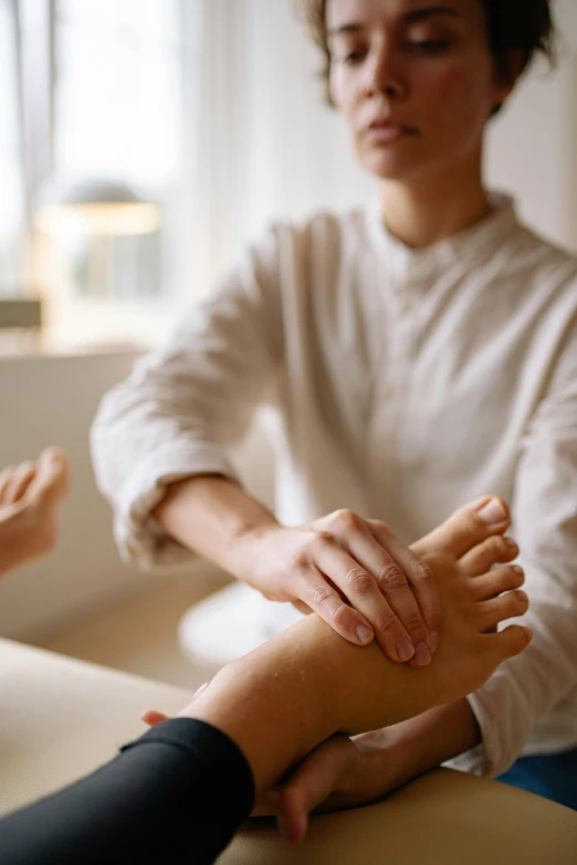 a woman getting a foot massage in a room, jen atkin, high-quality photo, caucasian, trustworthy