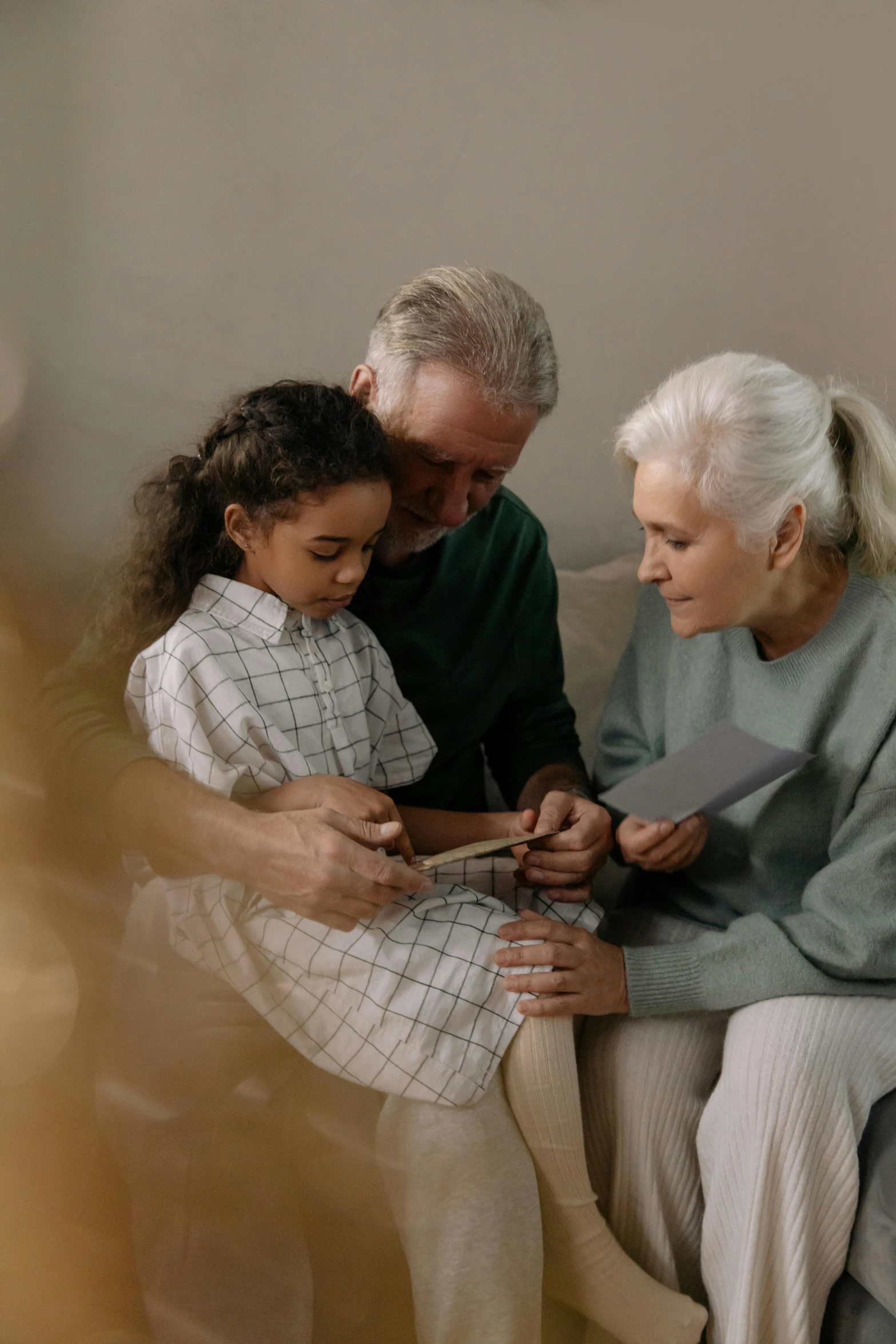 a family sitting on a couch looking at a cell phone, pexels contest winner, white-haired, gif, paul barson, healthcare